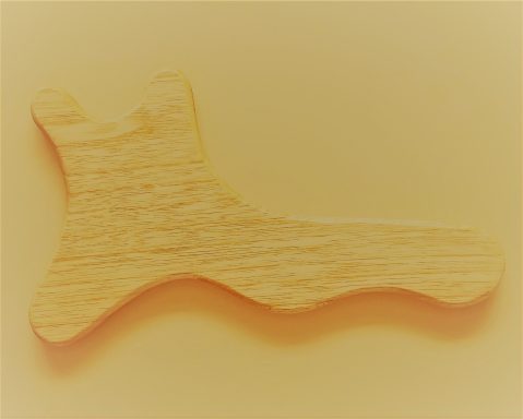 Holzfigur in Form eines stilisierten Fußes auf hellem Hintergrund.