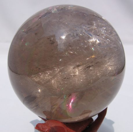 Kugel aus Rauchquarz mit schimmernden Farben, auf einem kleinen Sockel.
